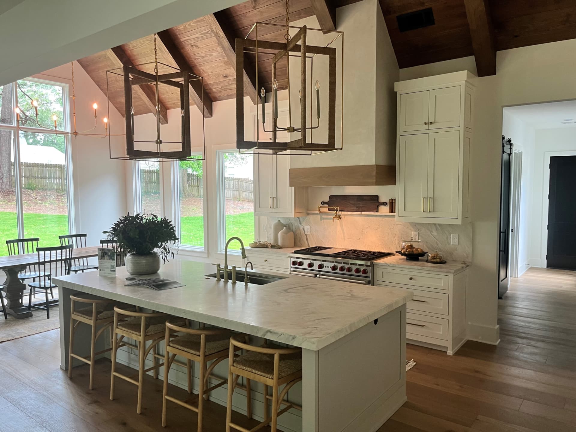 Stone kitchen island with white cabinetry and exposed ceiling beams